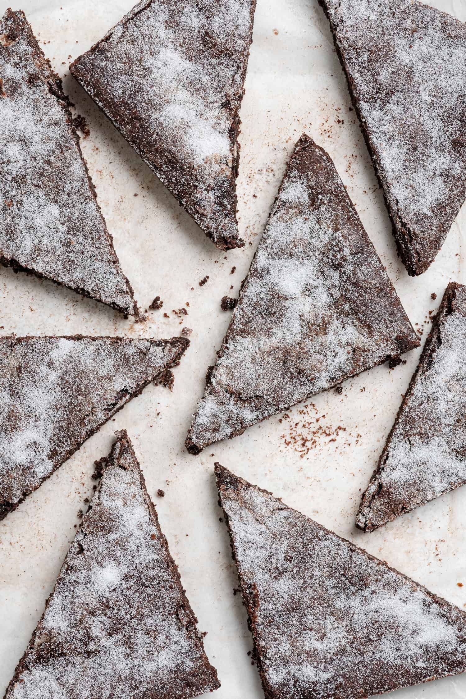 Triangles of vegan chocolate concrete on a sheet of baking paper.