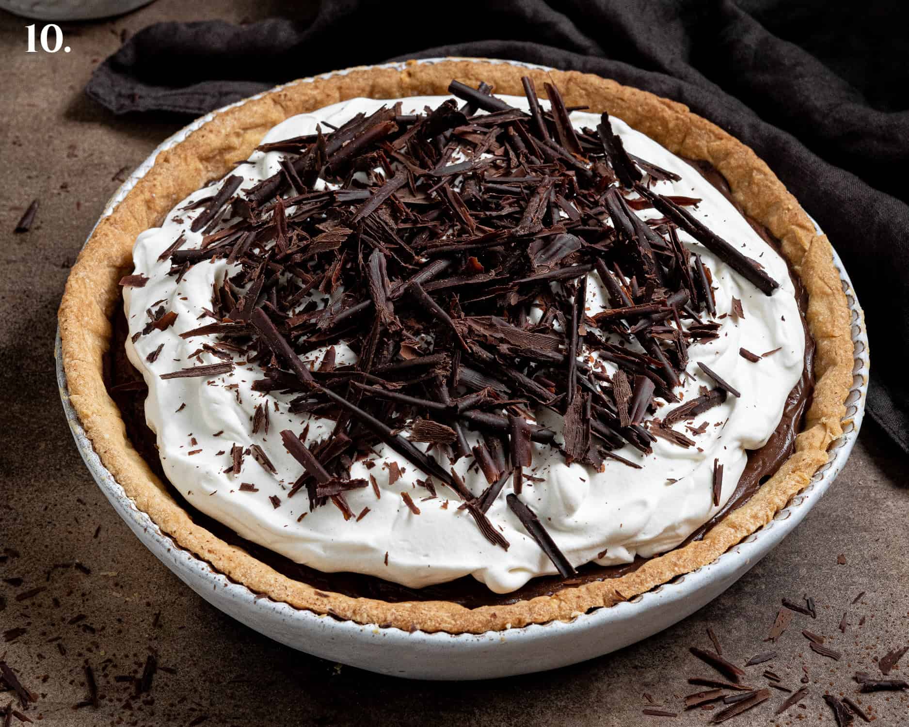 Step 10, the assembled pie with whipped cream and chocolate shavings on top.
