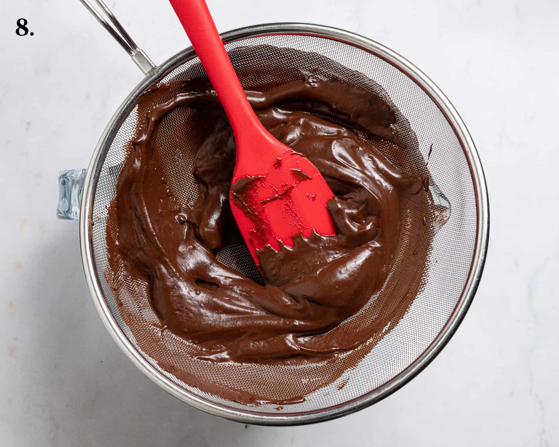 Step 8, scraping the chocolate pudding through a sieve.