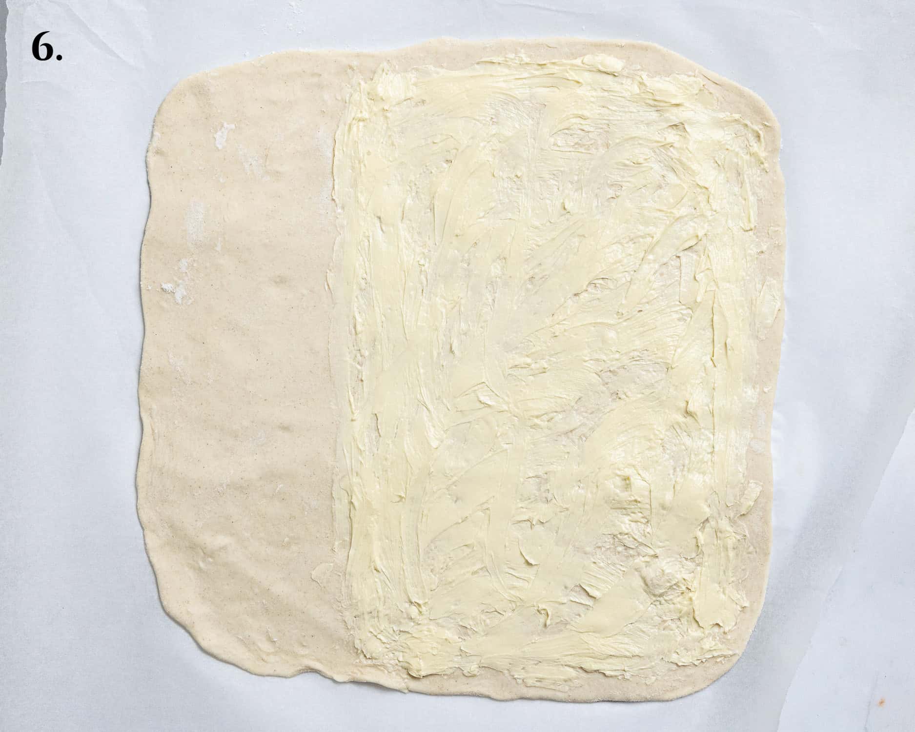 Step 6, the rolled out pastry spread with butter.