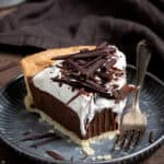 A slice of vegan chocolate cream pie on a metal plate with a forkful removed.