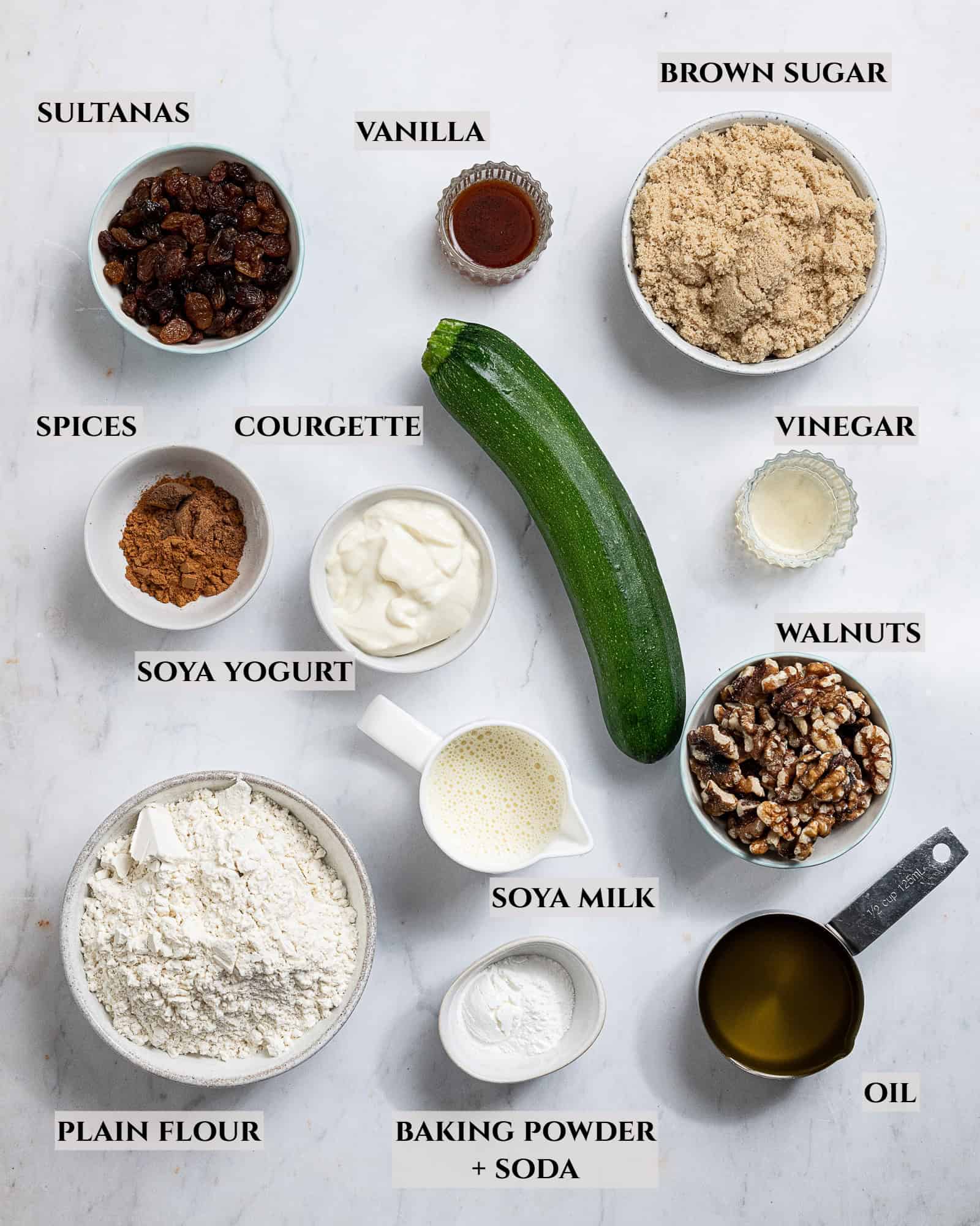 A labelled photo of the ingredients needed to make vegan courgette muffins.