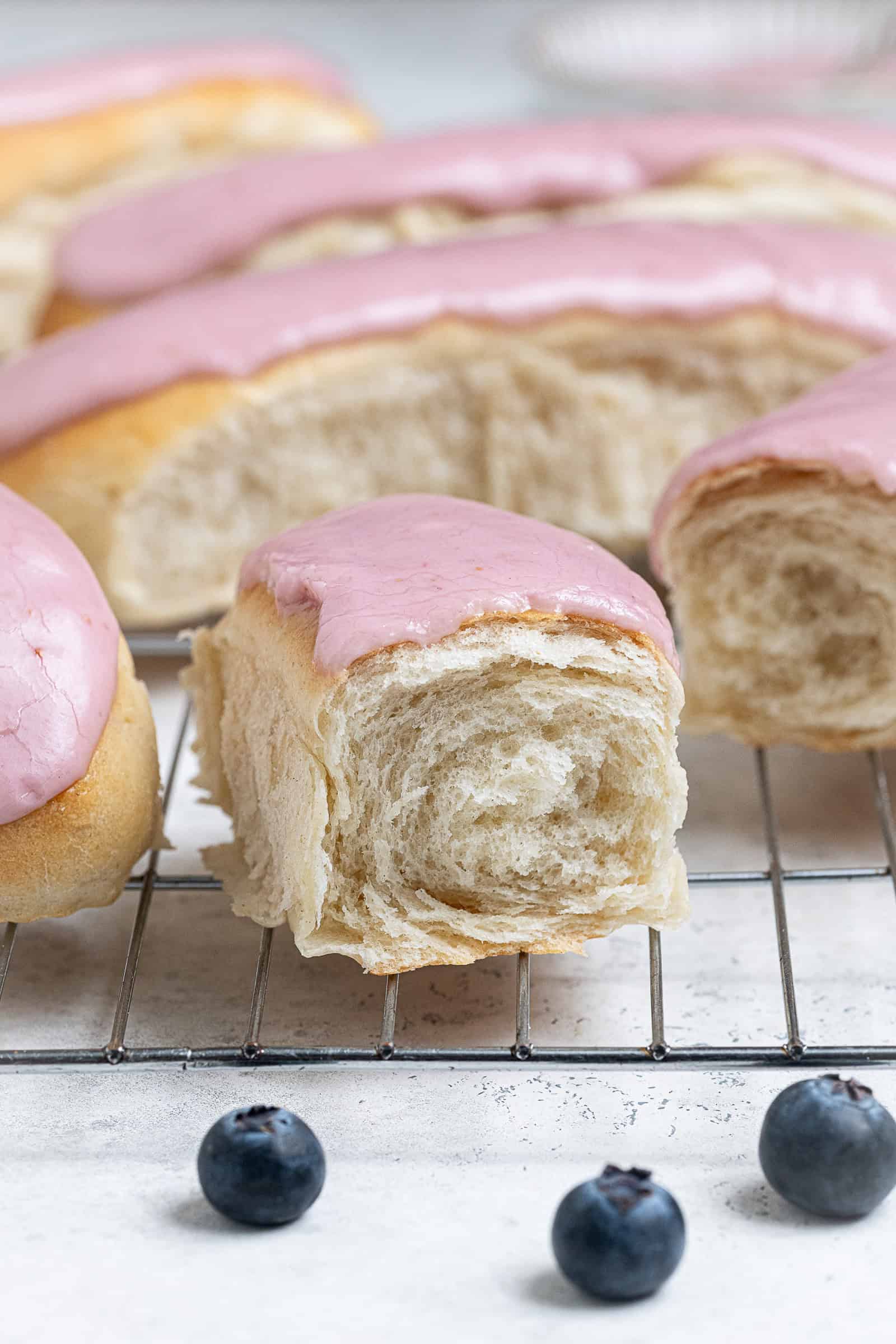 Close up shot of a vegan iced bun that has been torn in half.