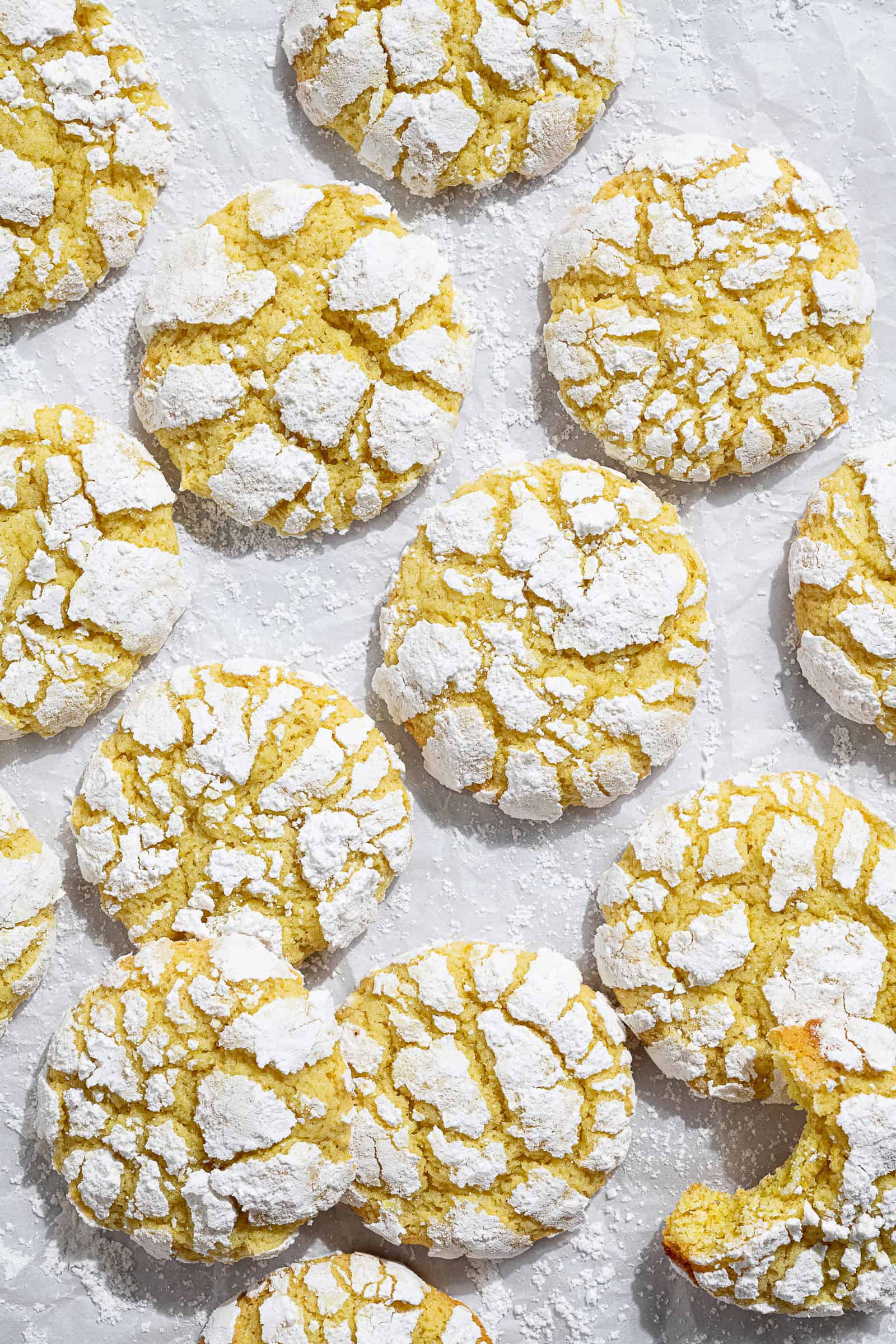 Vegan lemon crinkle cookies on a sheet of baking paper.