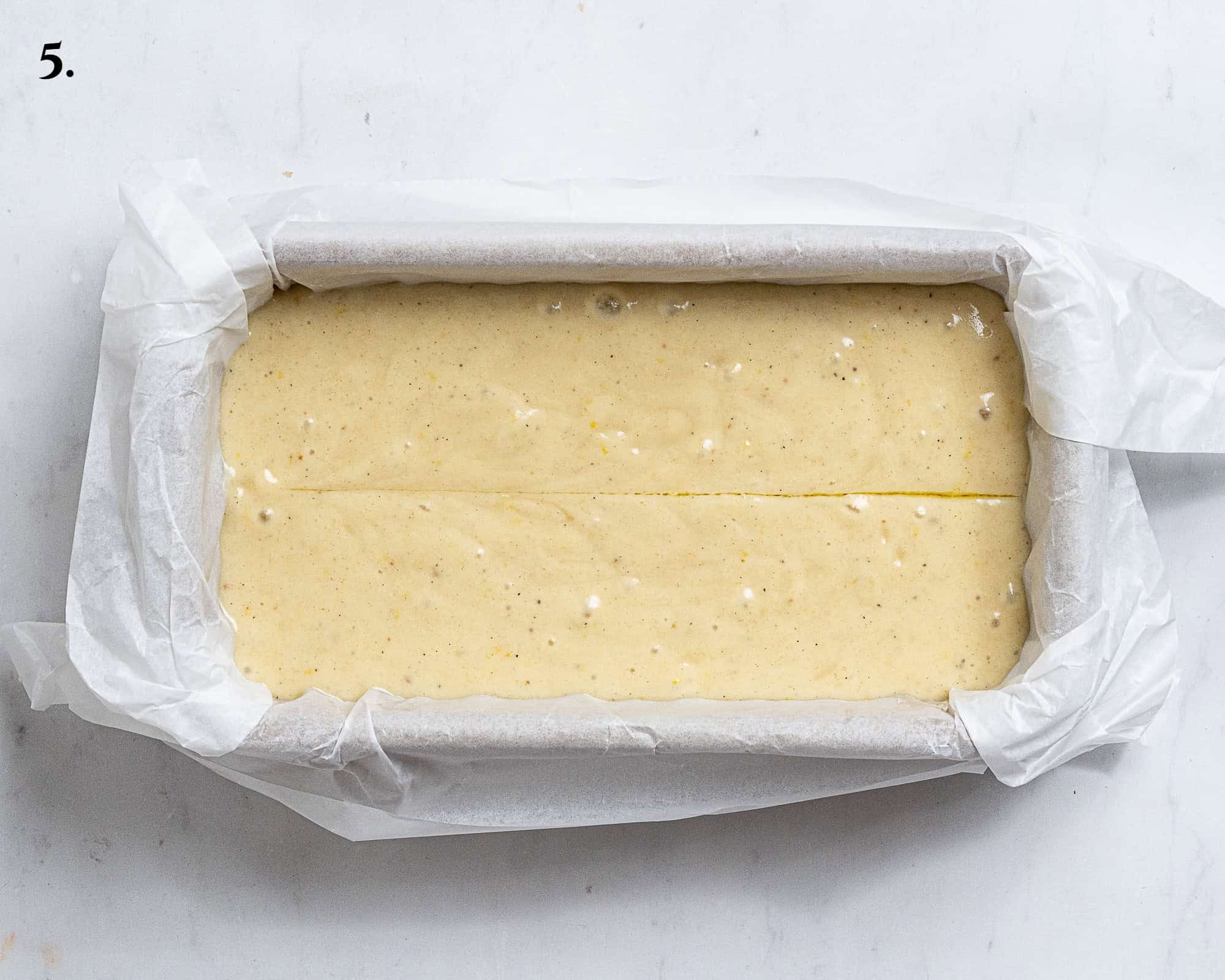 Step 5, the batter in the loaf tin with a line drawn down the centre with an oiled knife.
