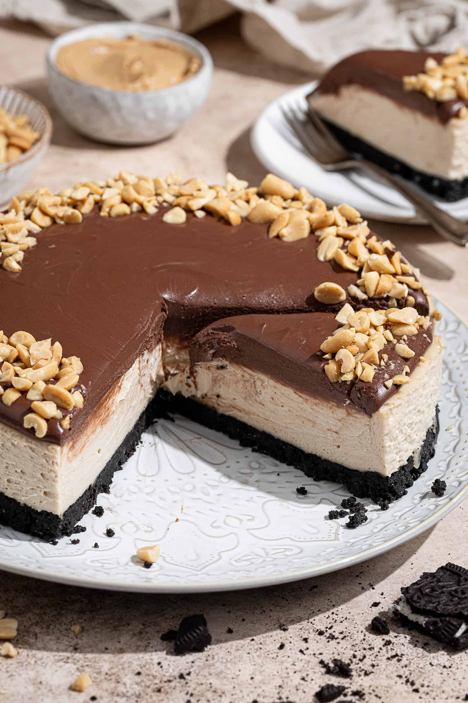 The sliced vegan no-bake peanut butter cheesecake on a white platter.