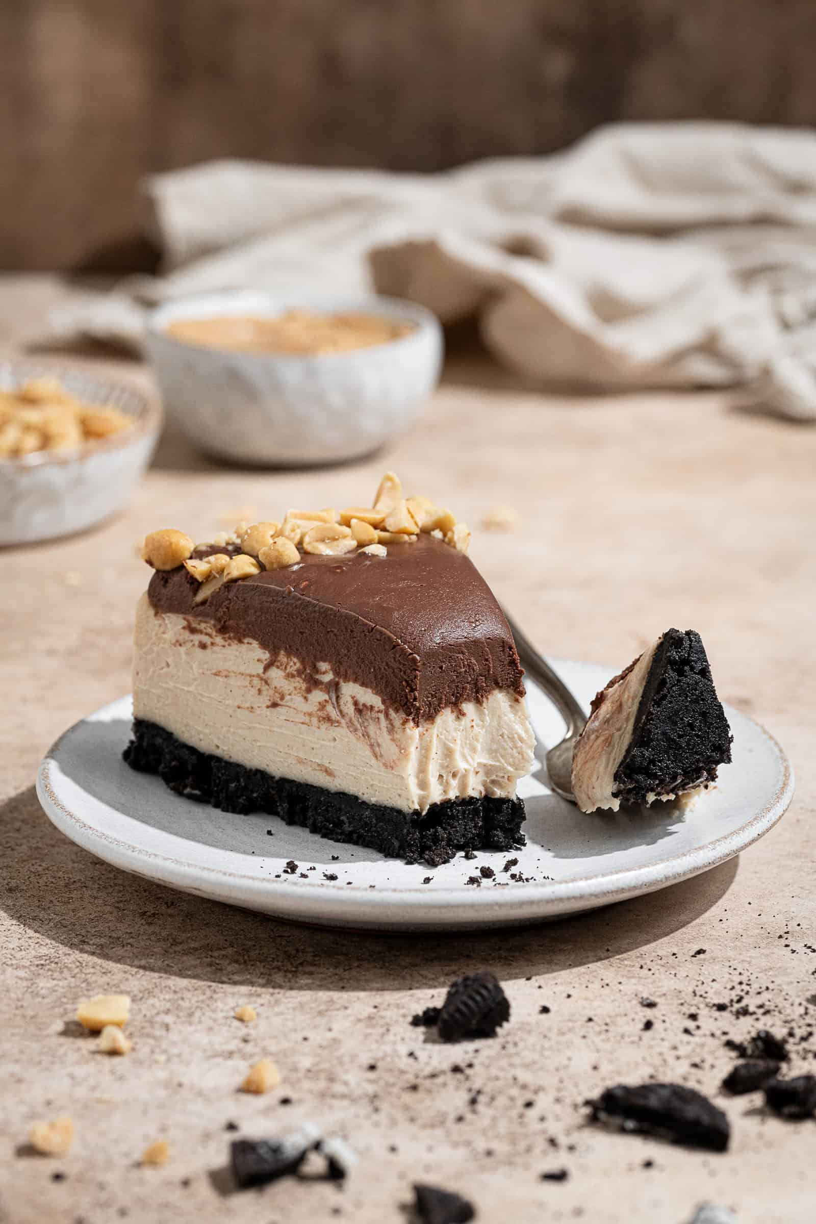 A slice of vegan no-bake peanut butter cheesecake on a plate with a fork.