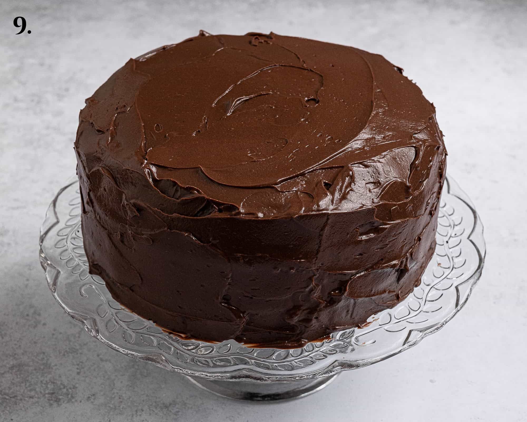 Step 9, the pudding coated cake on a cake stand.
