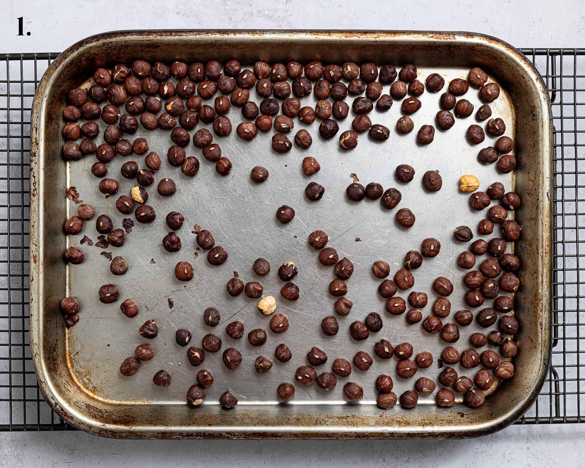 Step 1, the roasted hazelnuts on a tray.