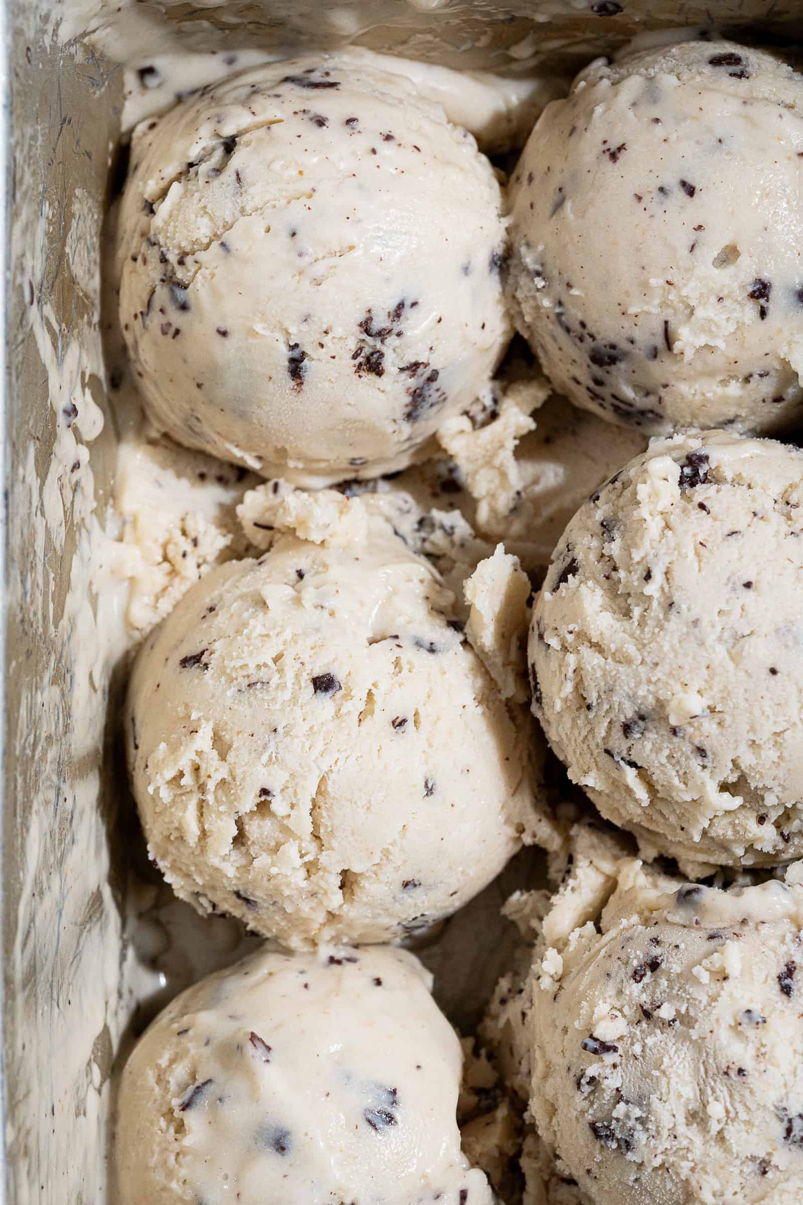 Scoops of vegan hazelnut stracciatella ice cream in a loaf tin.