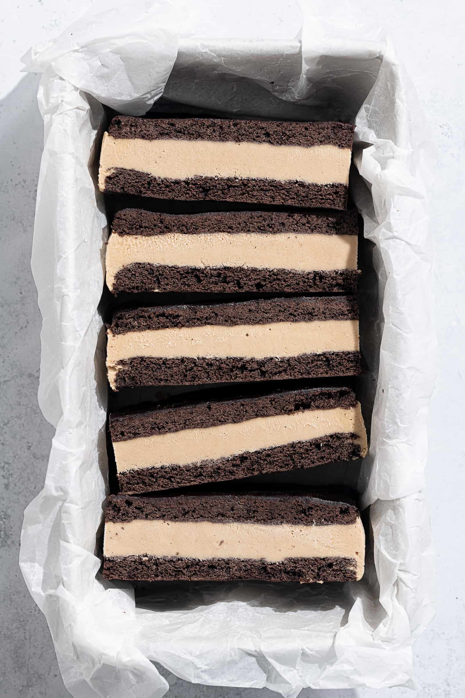 A row of vegan coffee ice cream sandwiches in a parchment lined loaf tin.