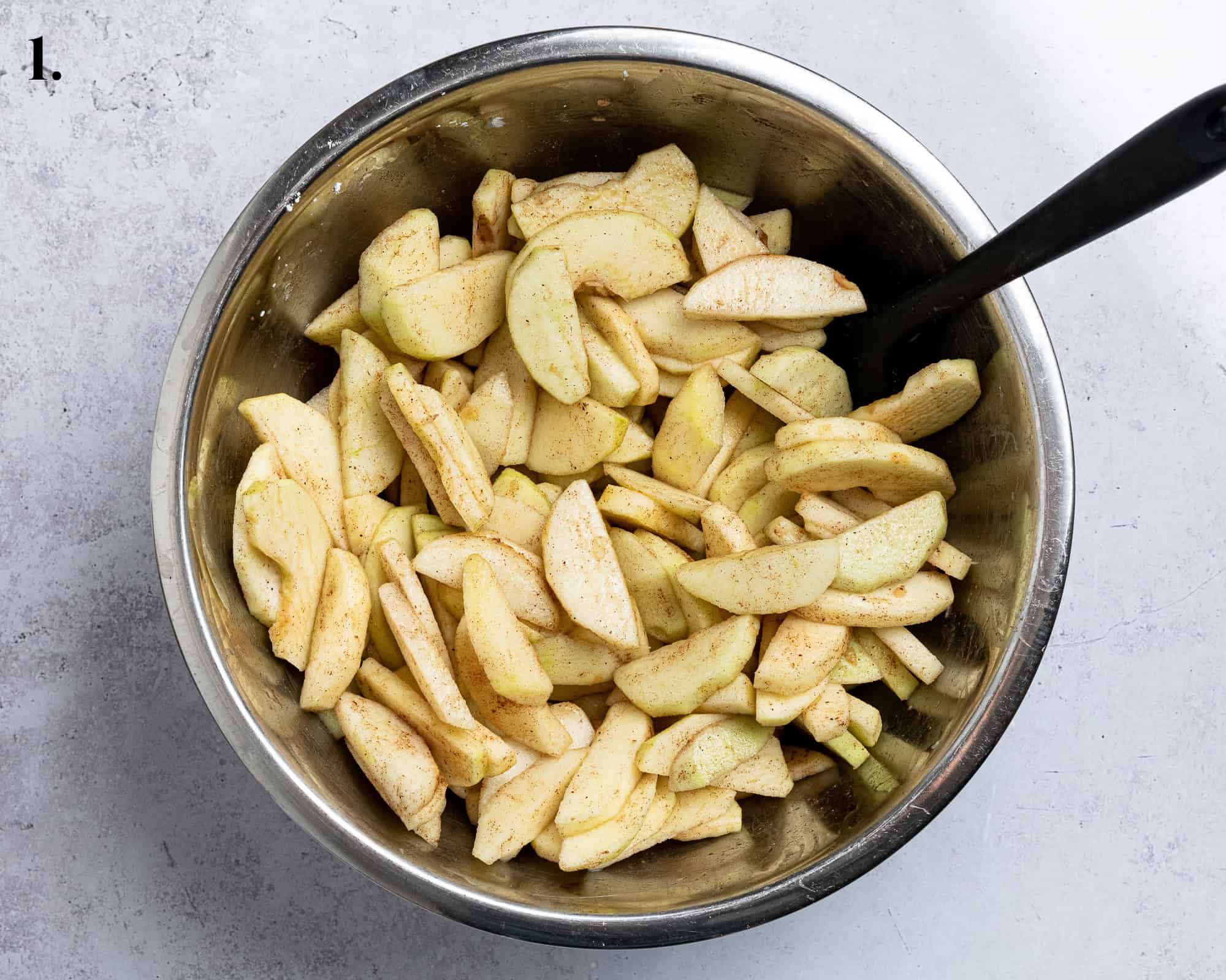 Step 1, the prepared apple slices in a bowl with the other filling ingredients.