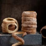 Vegan chimney cakes on a metal box on a dark background.