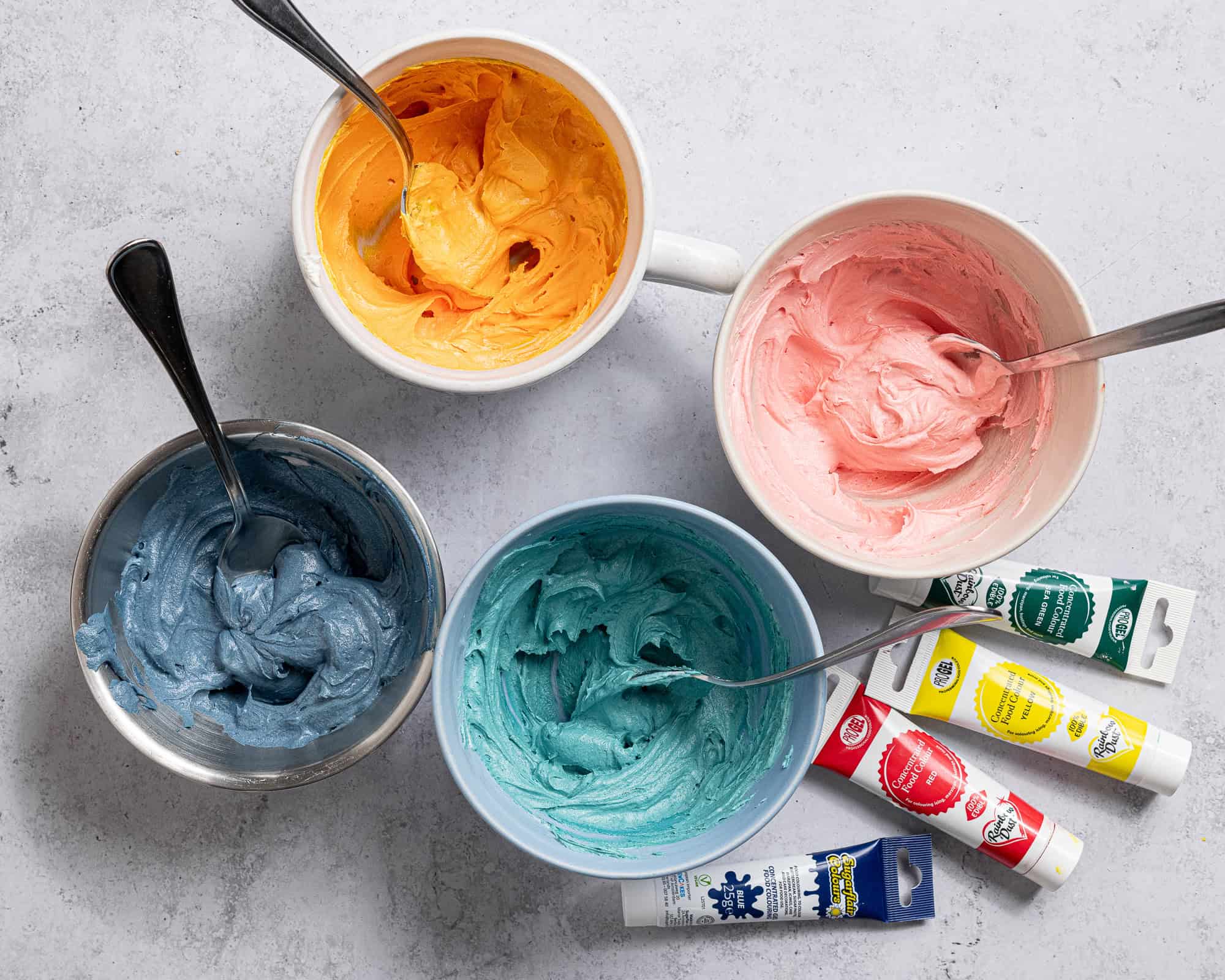 The coloured buttercream in small bowls.