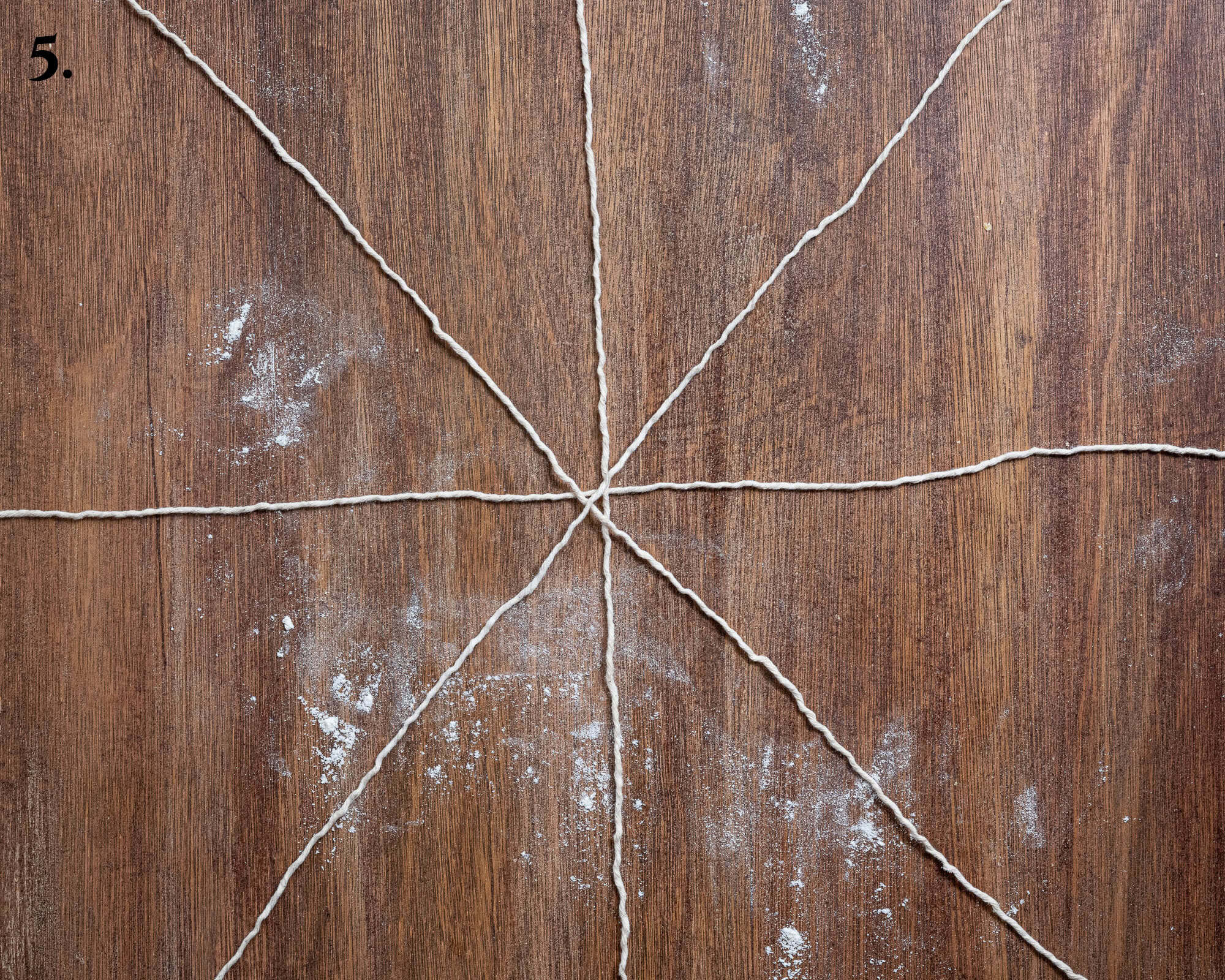 Step 5, the strings laid out on a wooden surface.